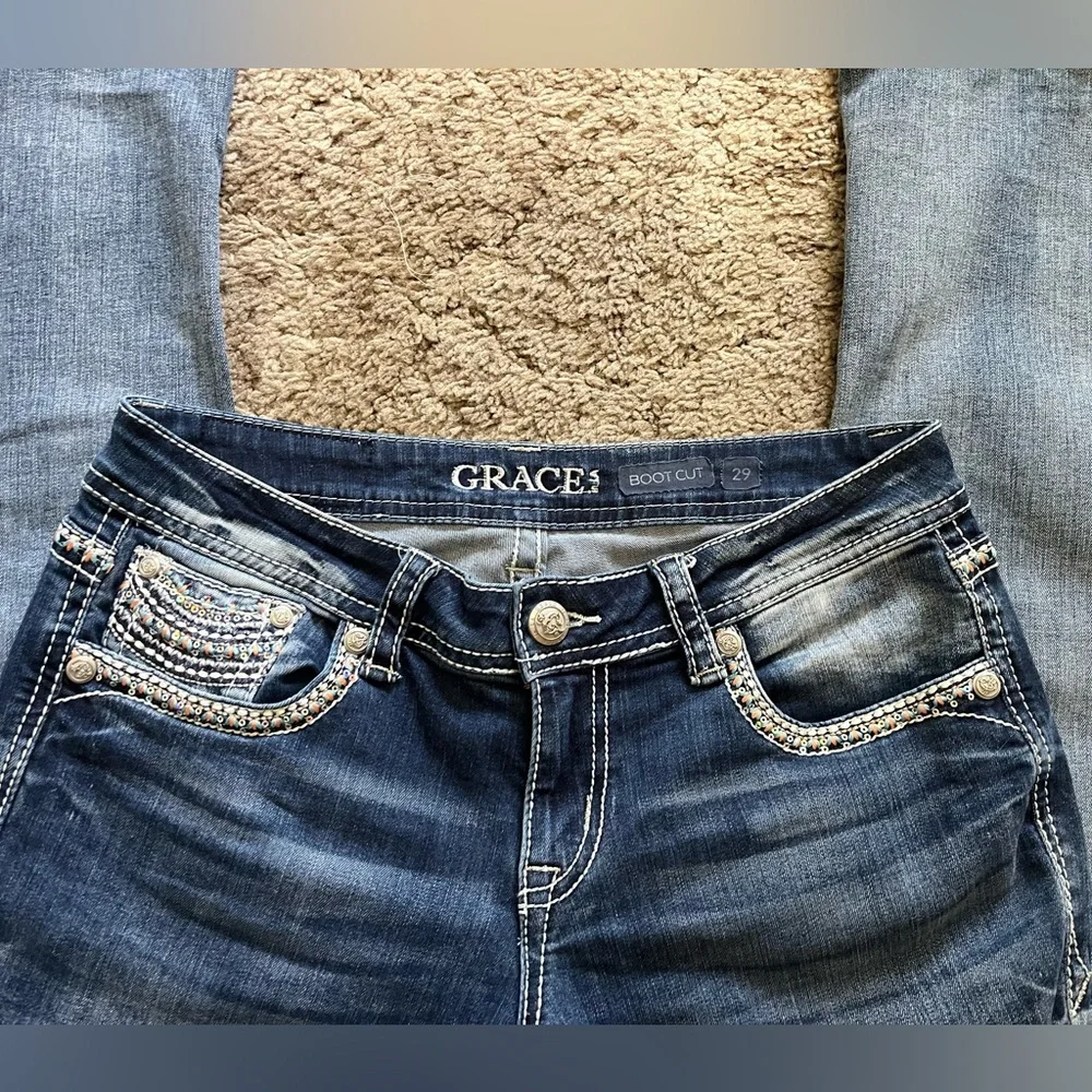 Grace in LA bootcut blue jeans with sequin and embroidery designs. Women’s 29